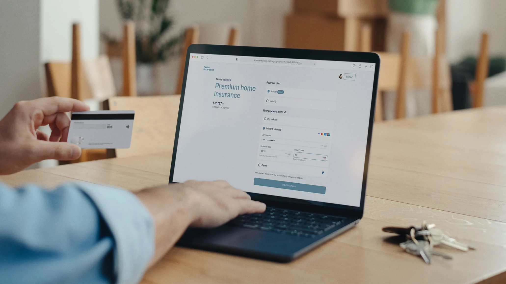 A person making a payment using an Adyen card reader while viewing a transaction on a laptop.