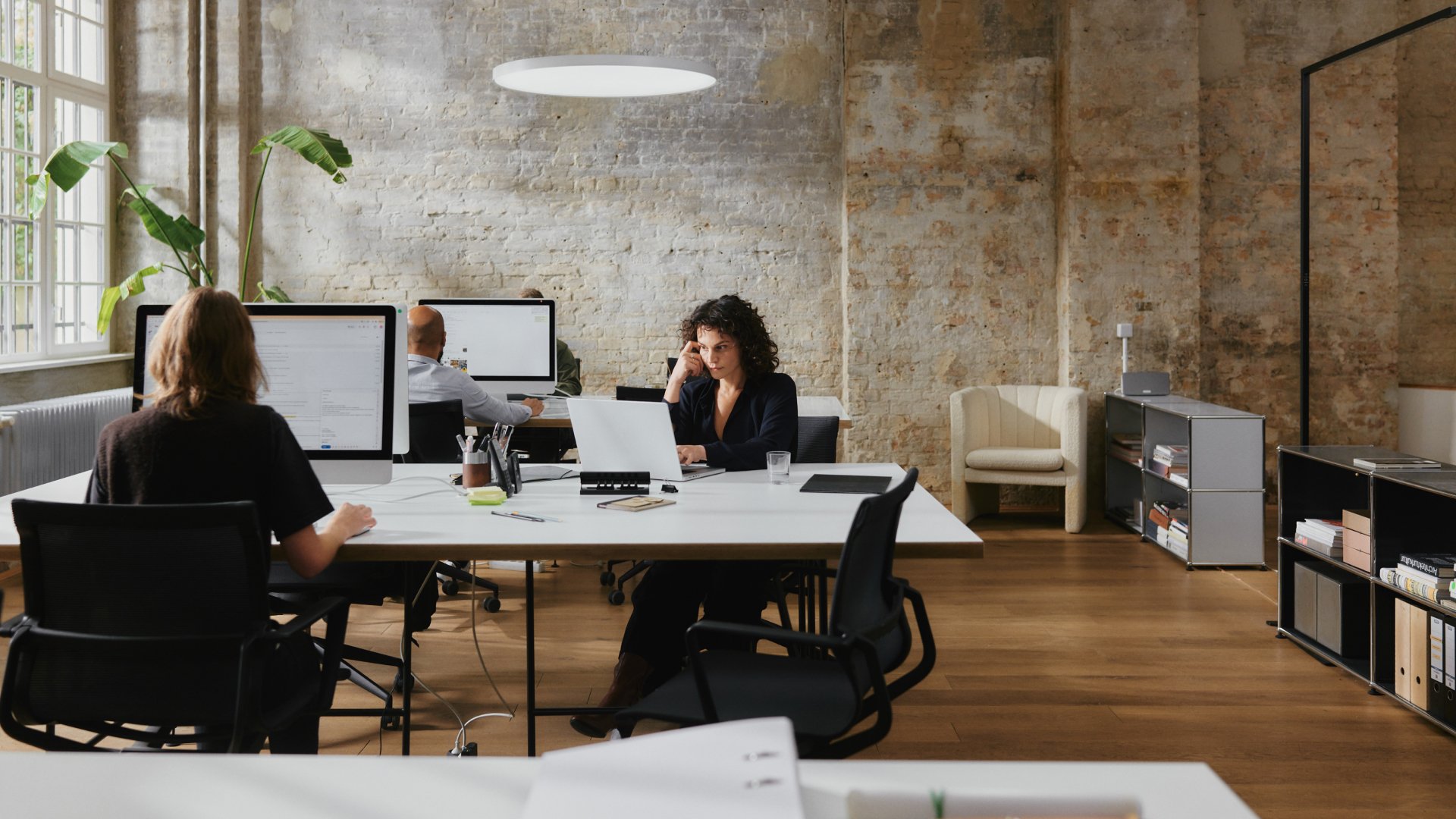 Adyen employees working in an office with computers and office furniture.