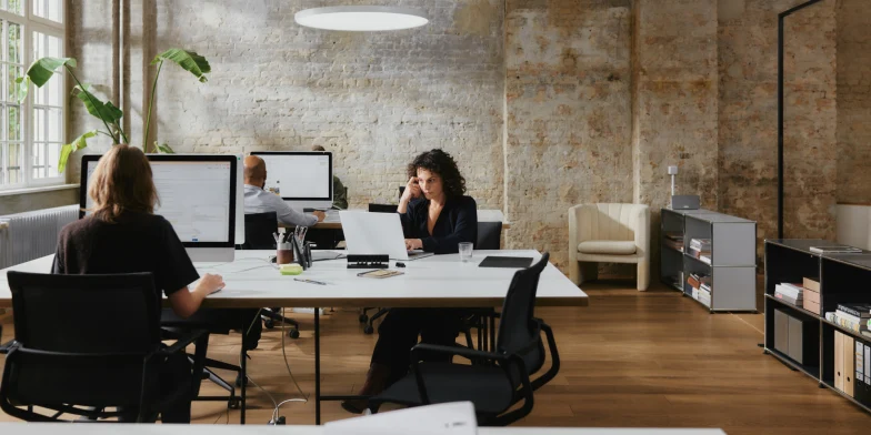 Adyen employees working in an office with computers and office furniture.