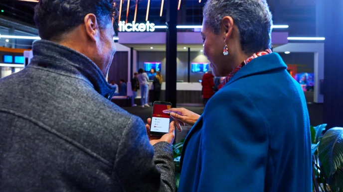 Kinobesucher kaufen Tickets für Filme auf dem Smartphone