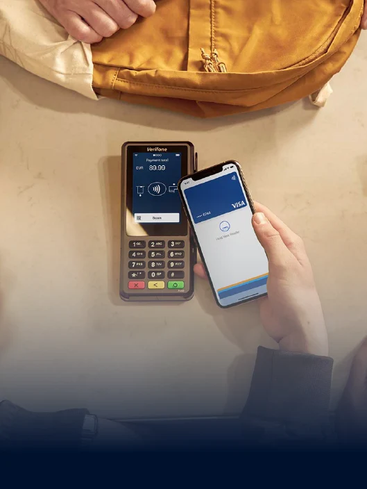 Um cliente paga com o telefone com cartão VISA no terminal da Adyen