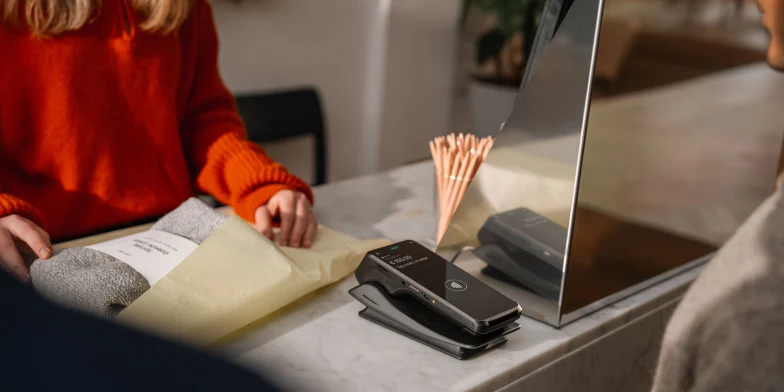 Customer making a payment at an Adyen terminal in a retail setting