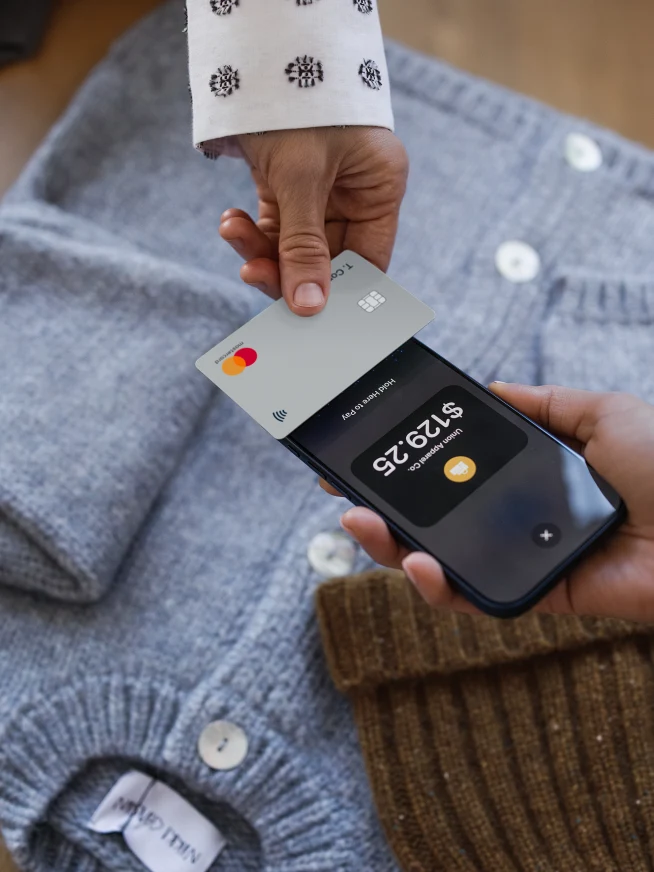 A person makes a payment using a mobile device and a contactless card with Adyen.