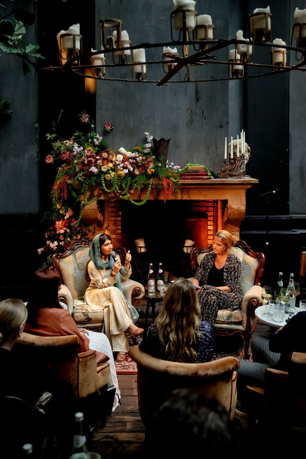 Adyen team members engaged in a discussion in a cozy, decorated indoor setting with floral arrangements and a fireplace.
