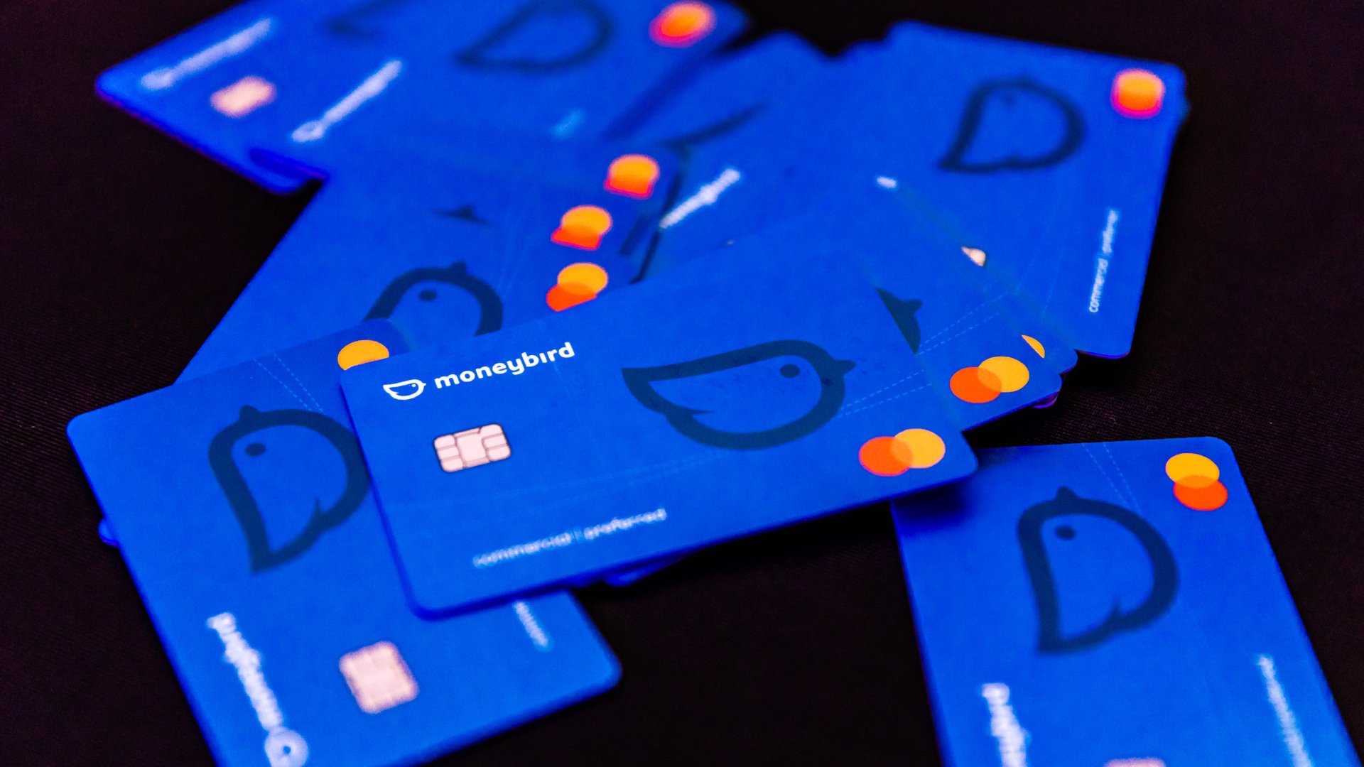 Verspreide blauwe betaalkaarten met Moneybird-logo en EMV-chip