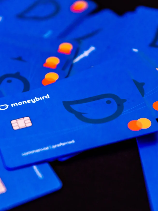 Verspreide blauwe betaalkaarten met Moneybird-logo en EMV-chip