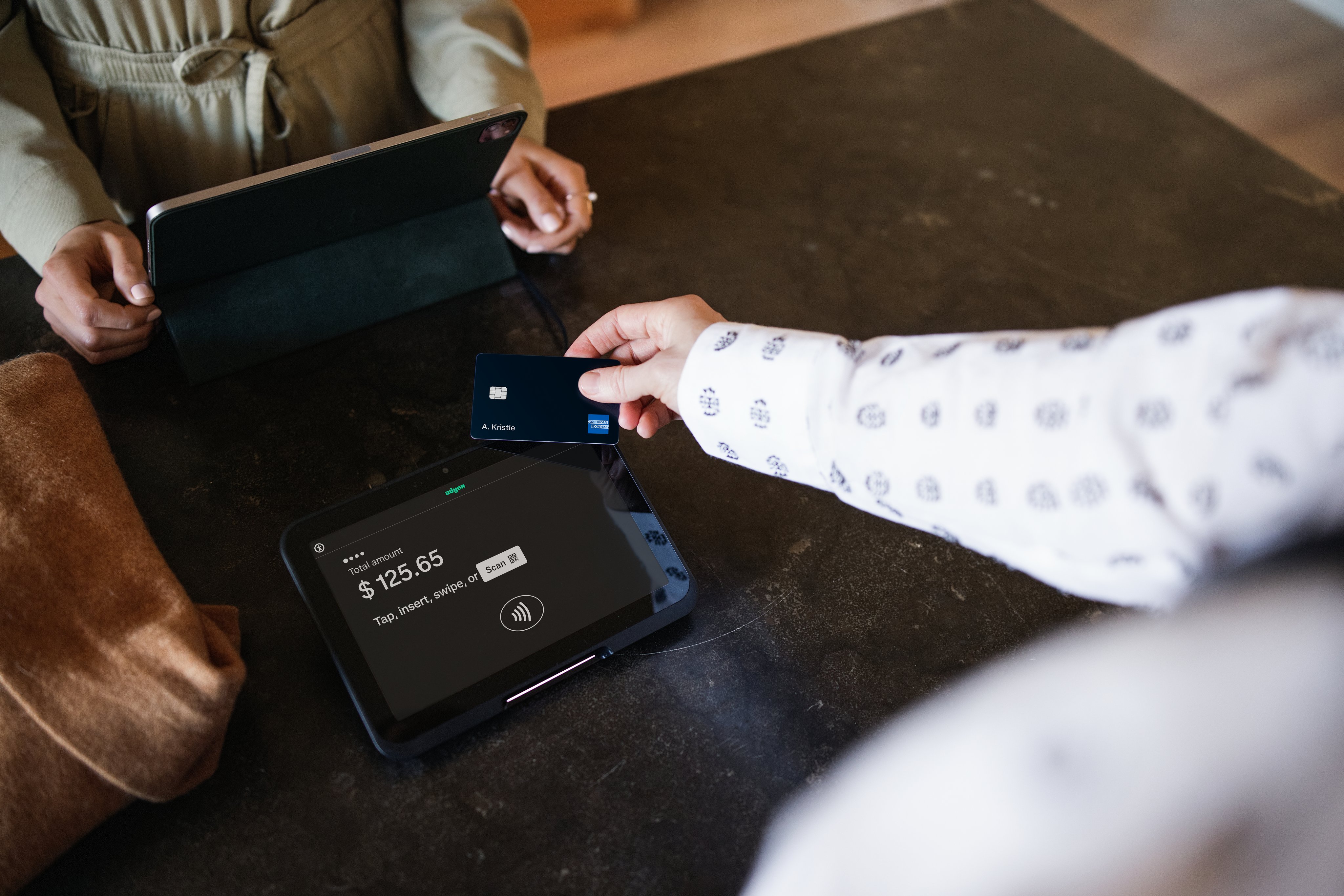Customer makes a payment using an Adyen card terminal at a business counter