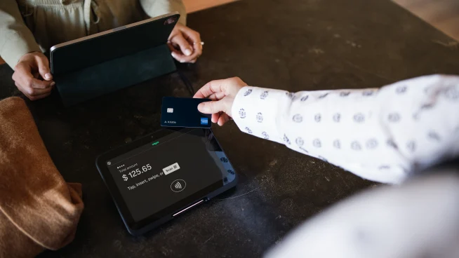 Customer makes a payment using an Adyen card terminal at a business counter