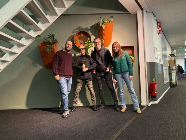 Adyen team members in an office displaying plants and modern decor smiling at the camera