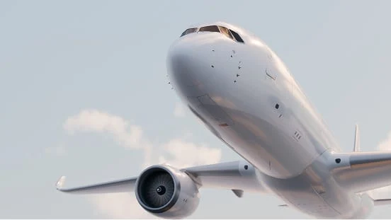 A white commercial airplane in flight, captured from below against a partly cloudy sky.