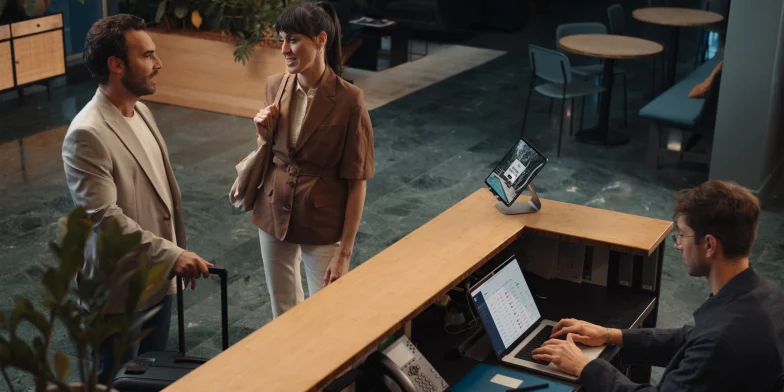 Adyen employees in the office interacting with customers at the reception desk.