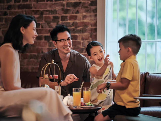 Una familia con niños disfrutando de dulces y bebidas en un bar de hotel.