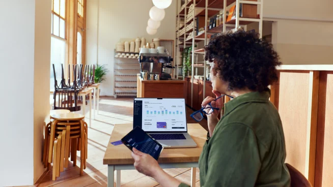 Coffee shop owner looking at their Adyen dashboard through a SaaS platform for food & beverage.
