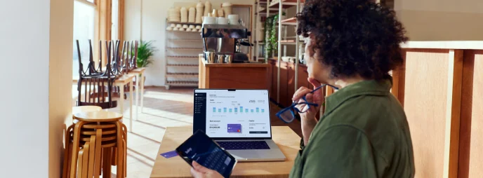 Coffee shop owner looking at their Adyen dashboard through a SaaS platform for food & beverage.