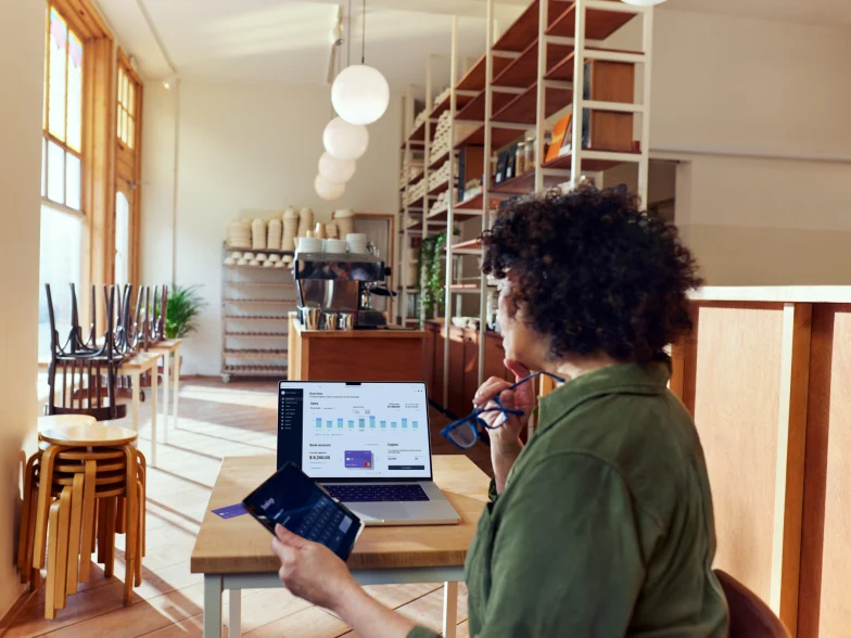 Coffee shop owner looking at their Adyen dashboard through a SaaS platform for food & beverage.