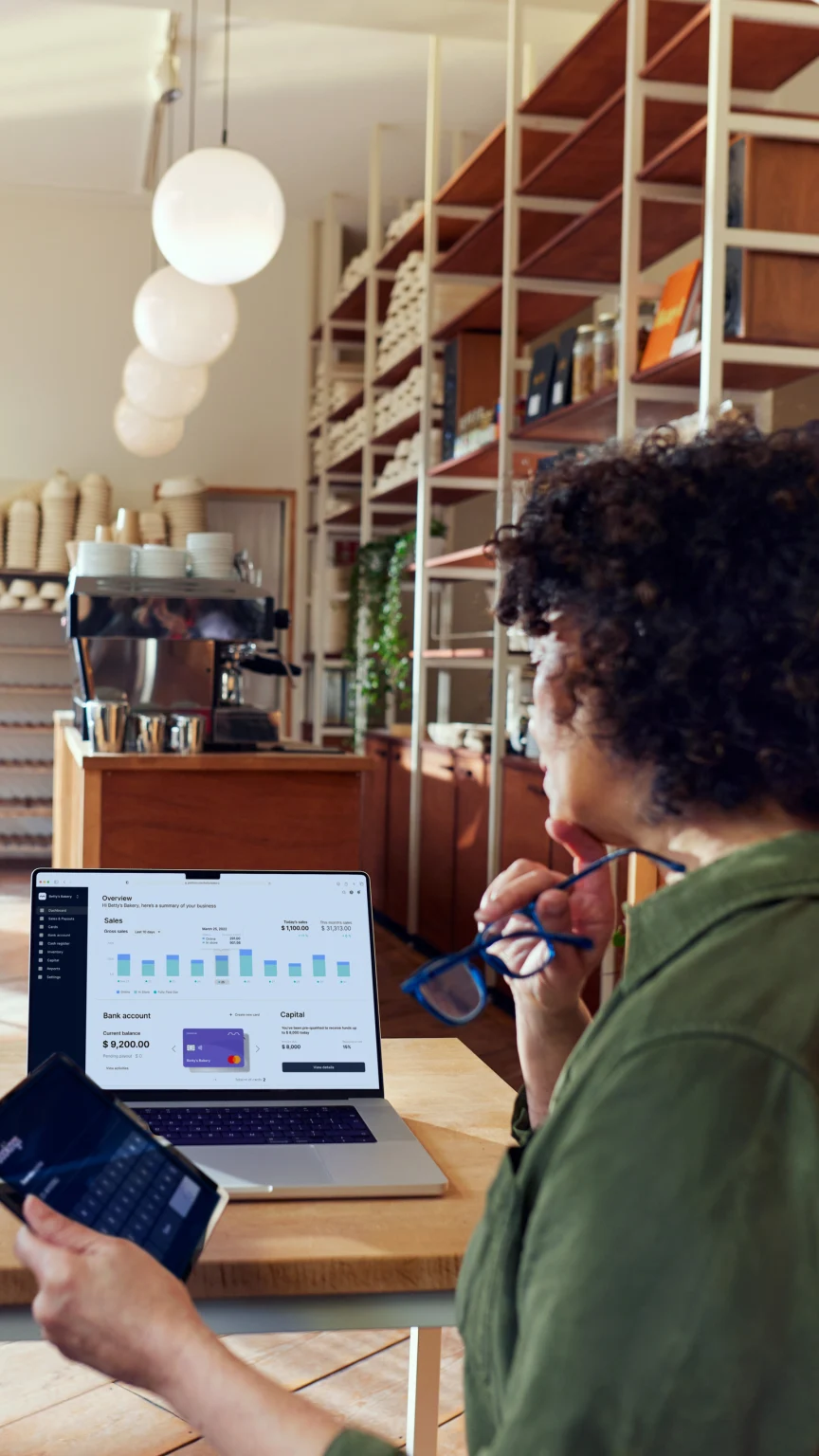 Coffee shop owner looking at their Adyen dashboard through a SaaS platform for food & beverage.