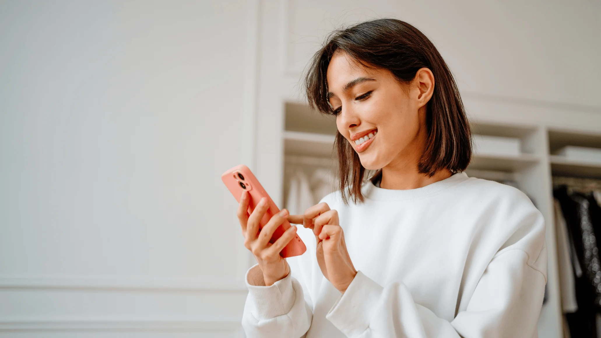 A person using a smartphone, with a payment terminal showing an Adyen logo nearby.