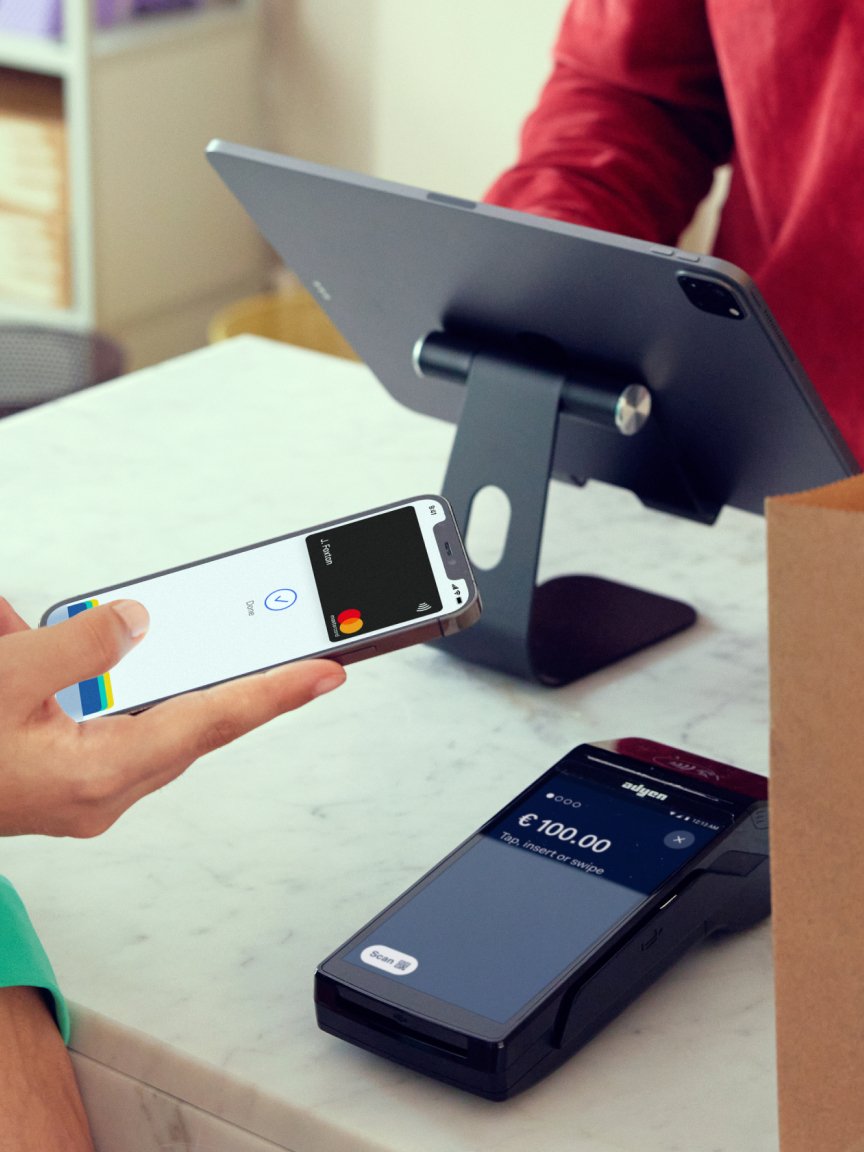 Personne utilisant un smartphone pour effectuer un paiement sur un terminal Adyen.