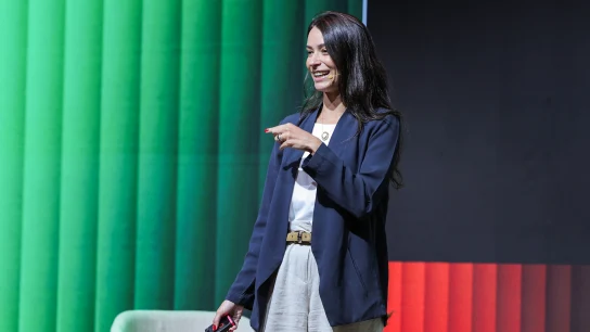 Membro da equipe da Adyen fazendo apresentação no palco com fundo colorido em evento interno.