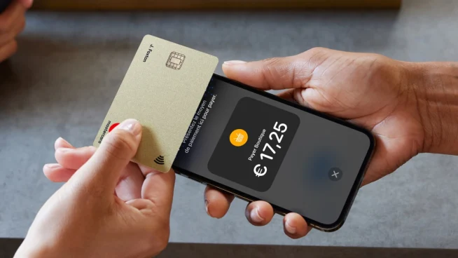 Mains tenant une carte de crédit et un smartphone affichant un paiement de €17.25 avec l’interface Adyen.