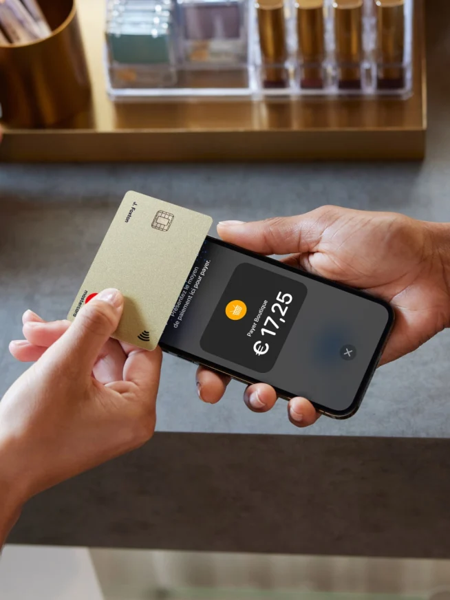 Mains tenant une carte de crédit et un smartphone affichant un paiement de €17.25 avec l’interface Adyen.