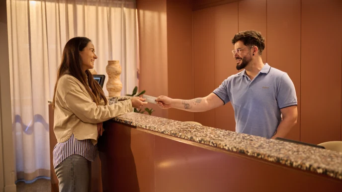 Adyen employee assisting a customer at the reception with a payment transaction.