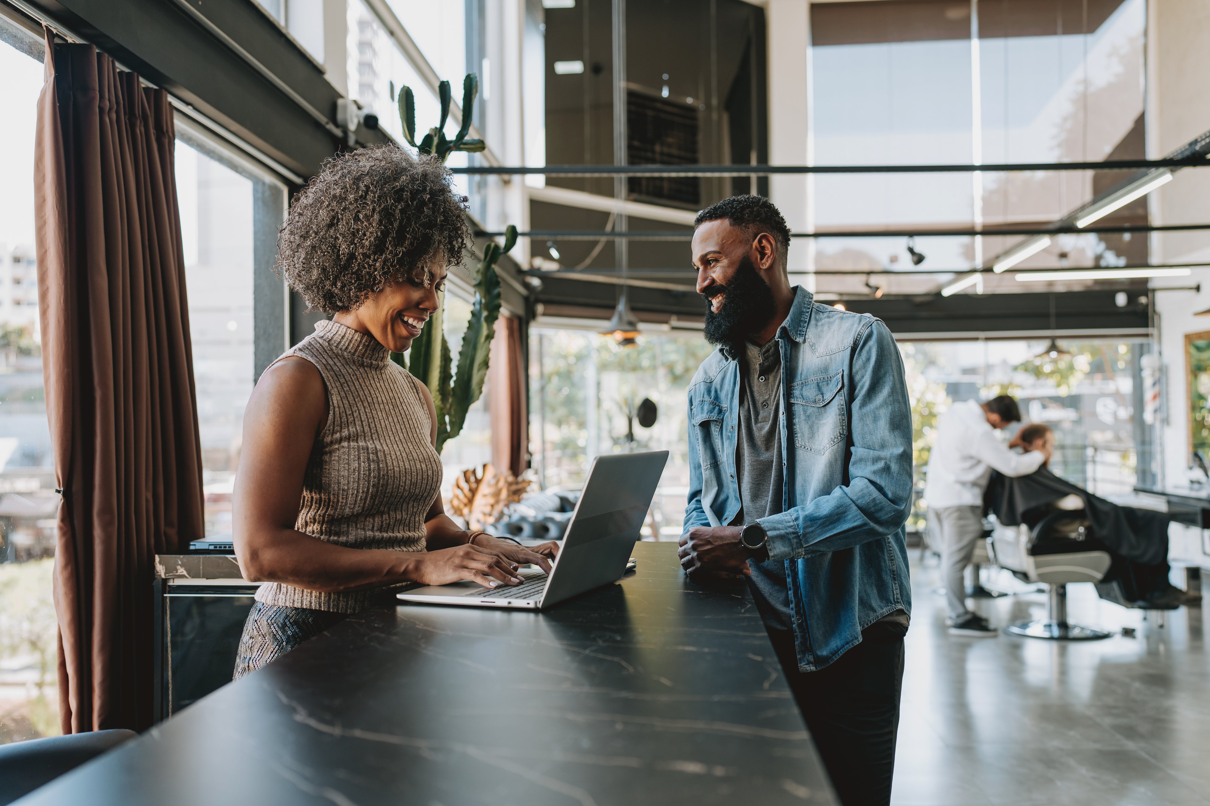 Receptionist serving customer at barbershop