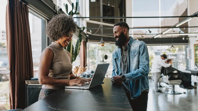 Receptionist serving customer at barbershop