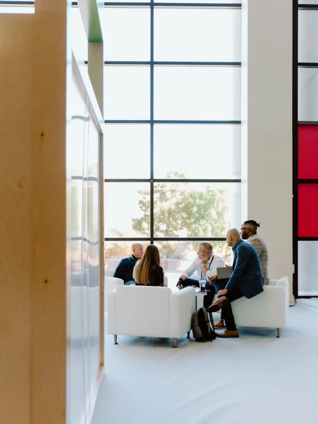 Adyen employees in the office engaging in a discussion, with payment activity provided by an Adyen terminal visible.