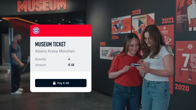 Travelers using an Adyen payment terminal to buy museum tickets at Allianz Arena Munich.