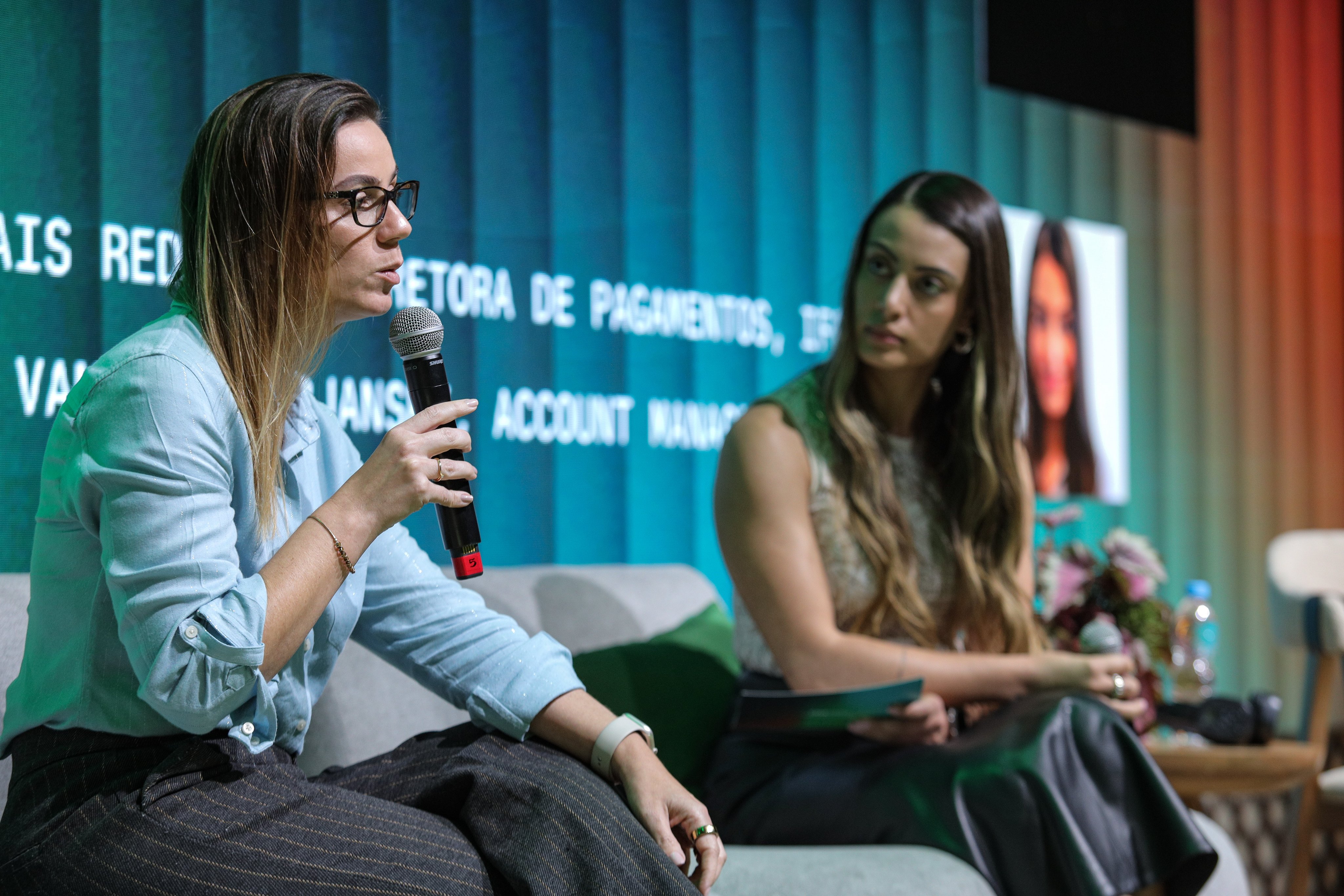 Equipe da Adyen em reunião profissional, com uma pessoa falando ao microfone durante apresentação.