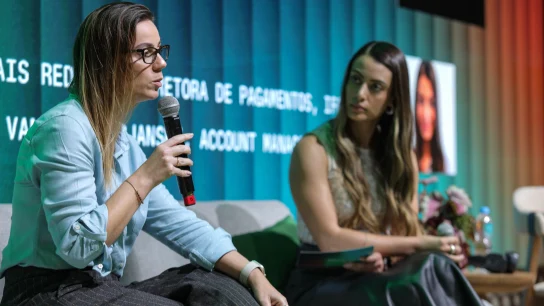 Equipe da Adyen em reunião profissional, com uma pessoa falando ao microfone durante apresentação.