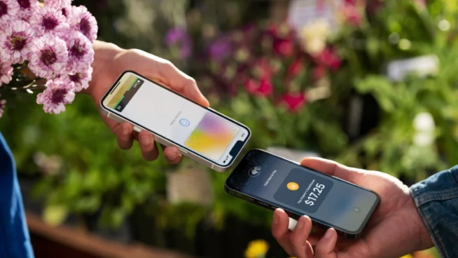 Two hands exchanging payment via smartphone with a visible transaction amount.