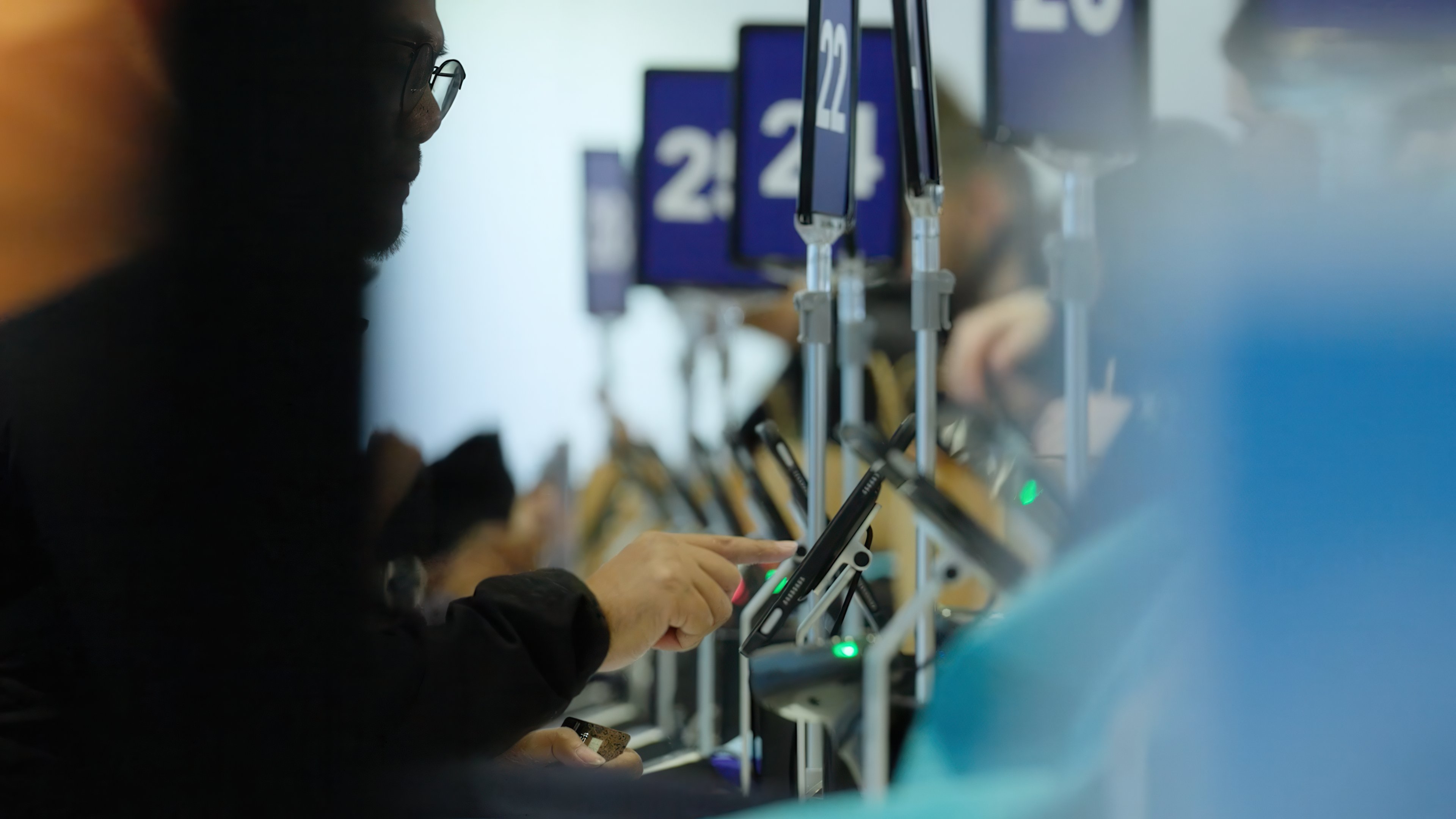 Adyen staff serving at a checkout counter with EFTPOS payment terminals in a retail store.