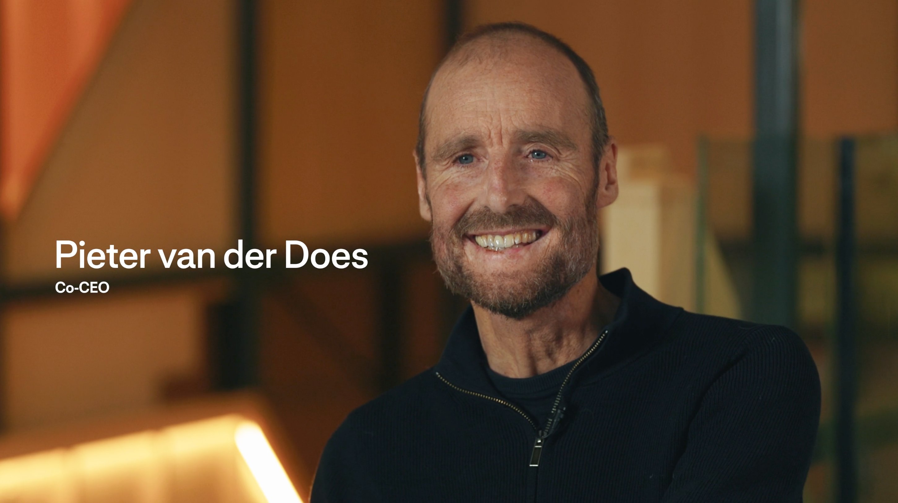 Membre de l'équipe Adyen souriant dans un bureau professionnel.