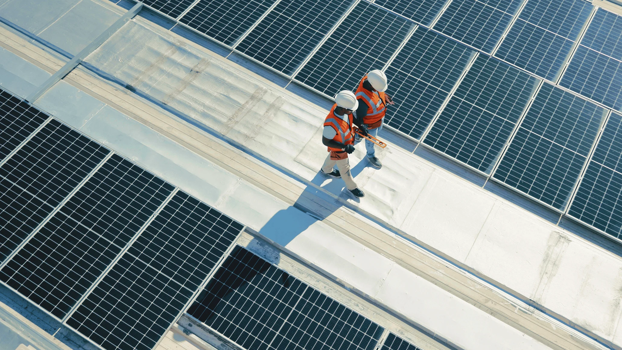 Adyen employees in the Adyen office inspecting solar panels on a rooftop during daylight.