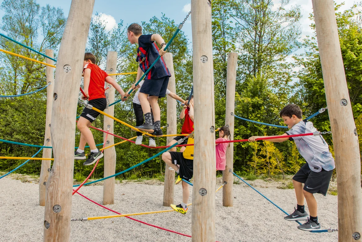 Kinder beim Klettern am Outdoorspielplatz