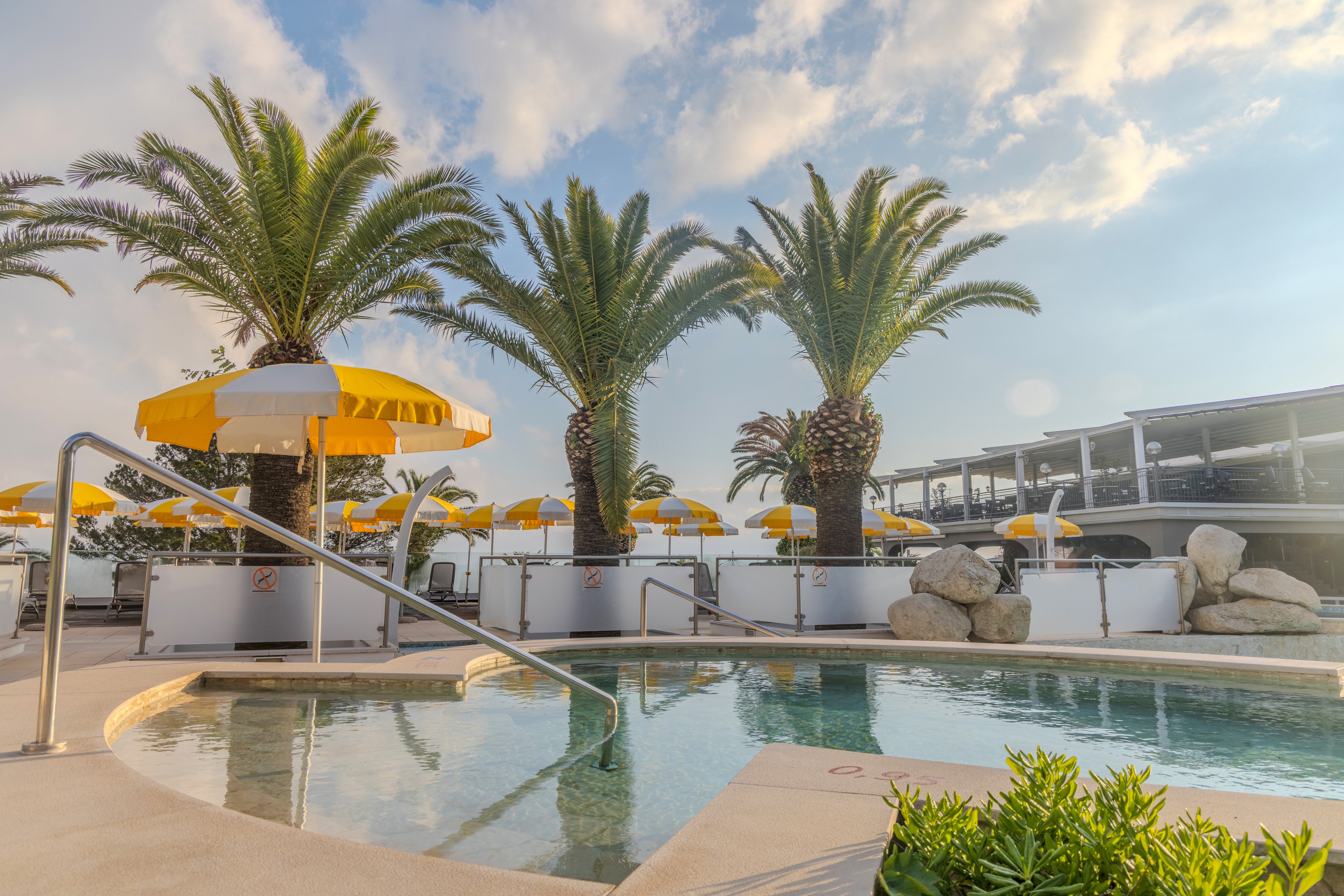 Schwimmbad im Premium Cluburlaub bei Aldiana mit Palmen und Sonnenschirmen