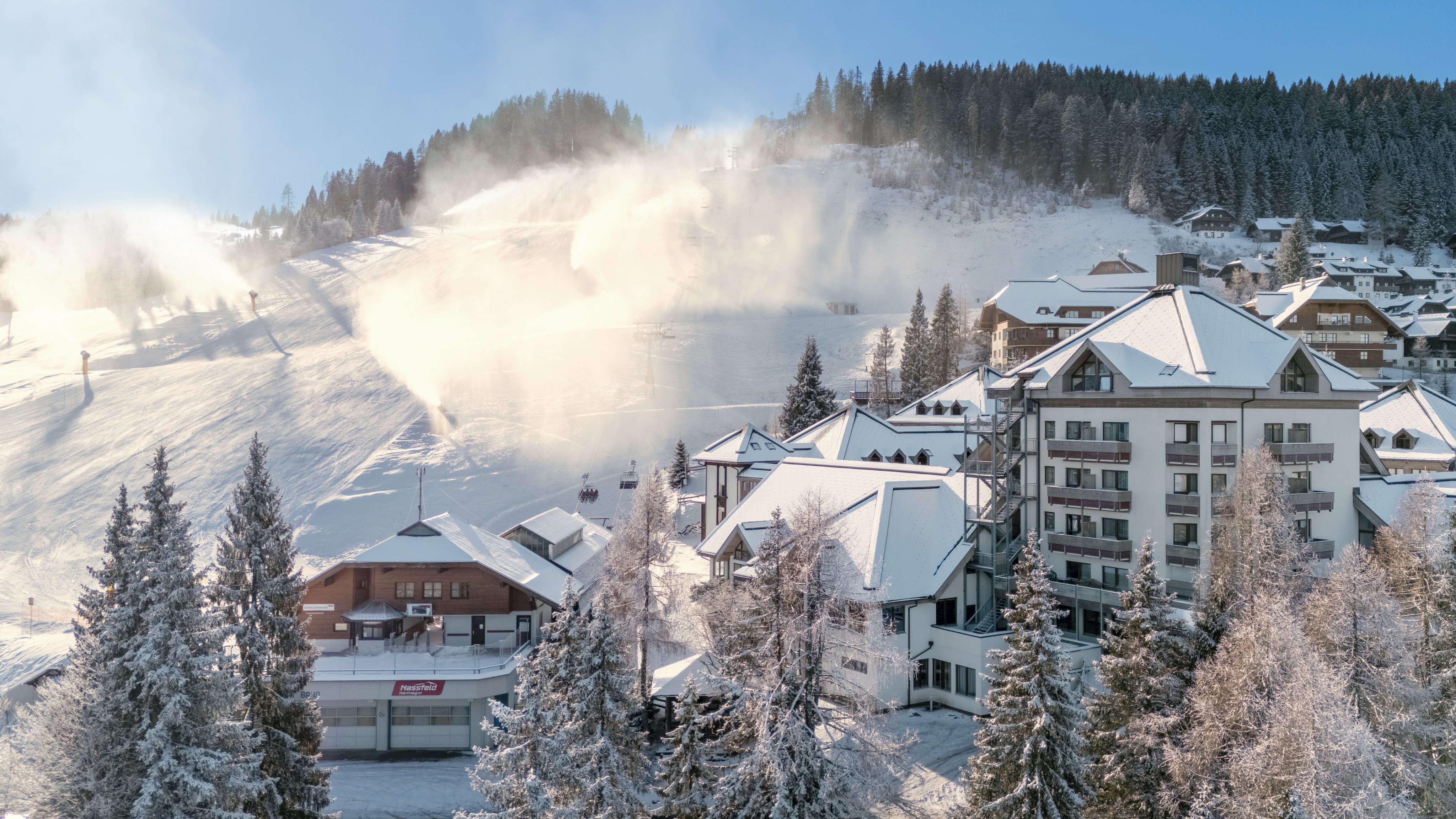 Schneebedecktes Bergdorf im Winter mit modernen Hotelanlagen und verschneiten Binnenbereichen
