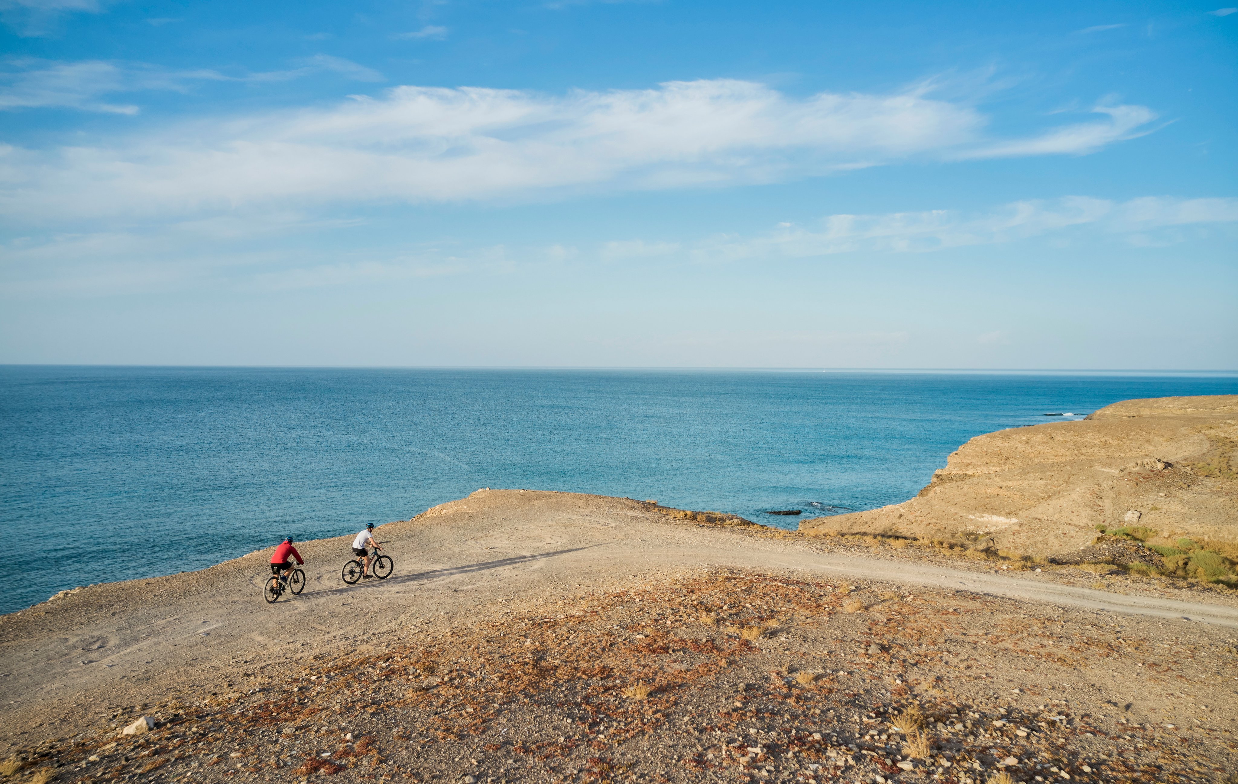 Zwei Radfahrer auf Klippe mit Meerblick bei Sonnenuntergang, Premium Cluburlaub bei Aldiana