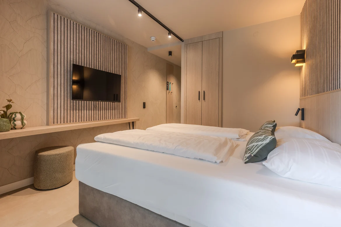 Modern Hotelzimmer von Aldiana mit stilvollem Bett und TV, barrierefrei gestaltet