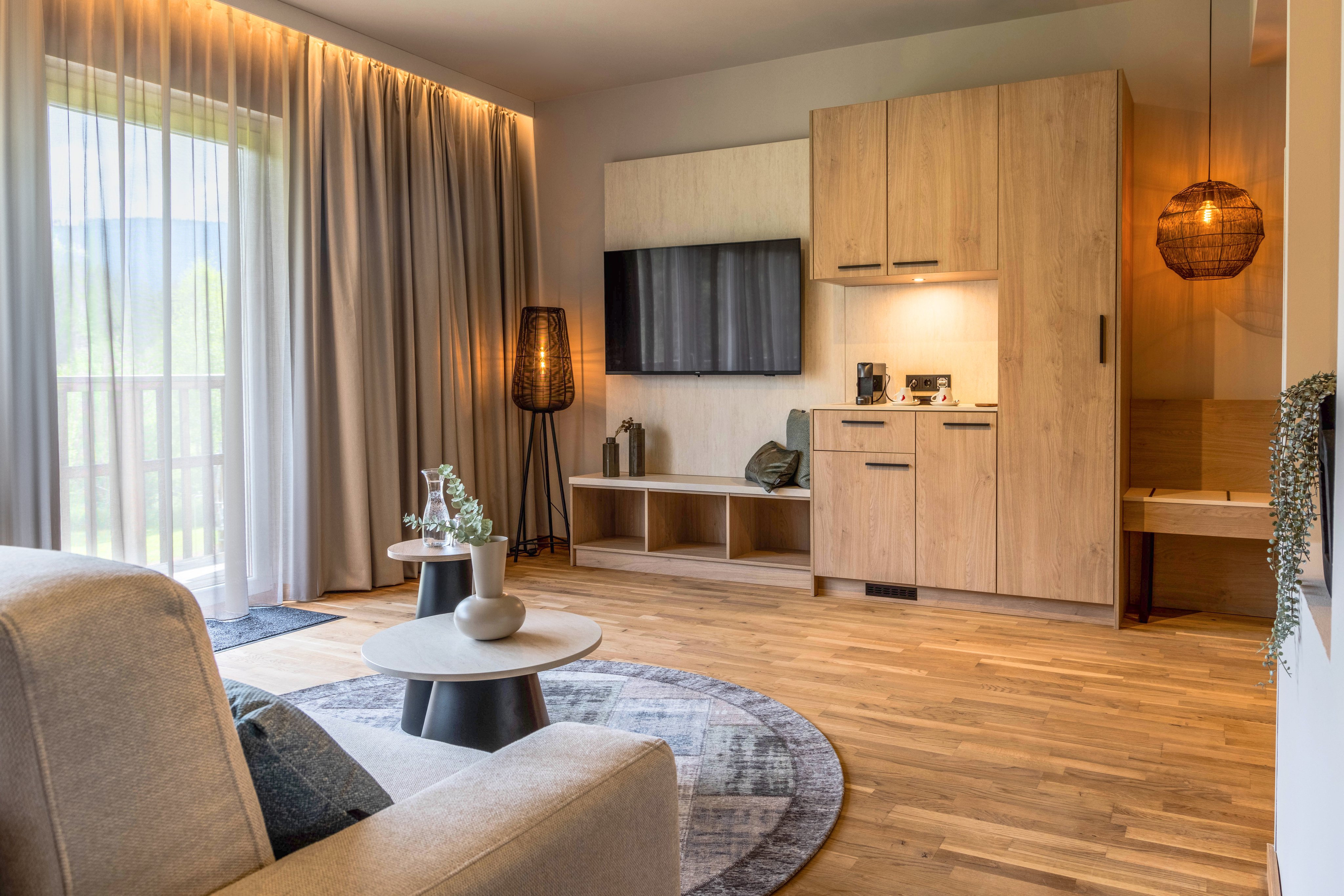 Gemütliches Hotelzimmer mit Sitzecke, Fernseher und moderner Ausstattung.