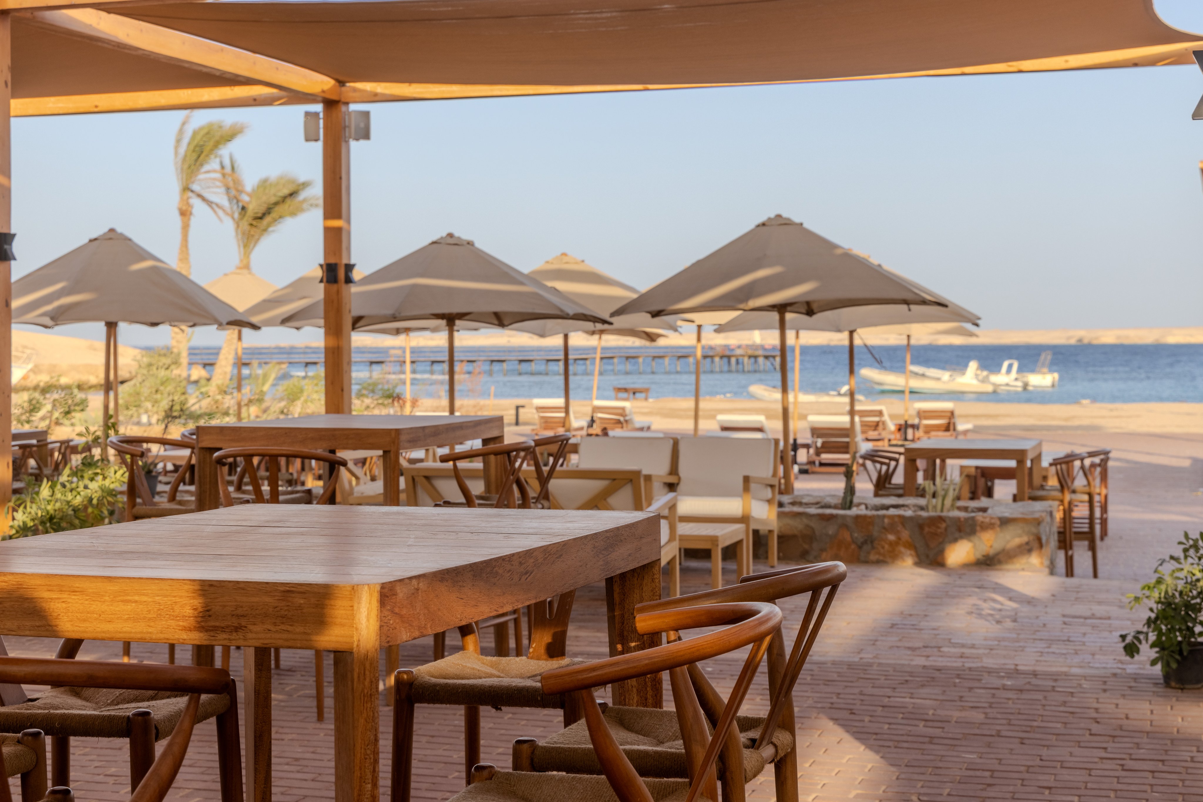 Strandbar im Aldiana Resort mit Sonnenschirmen, Tischen und Blick aufs Meer