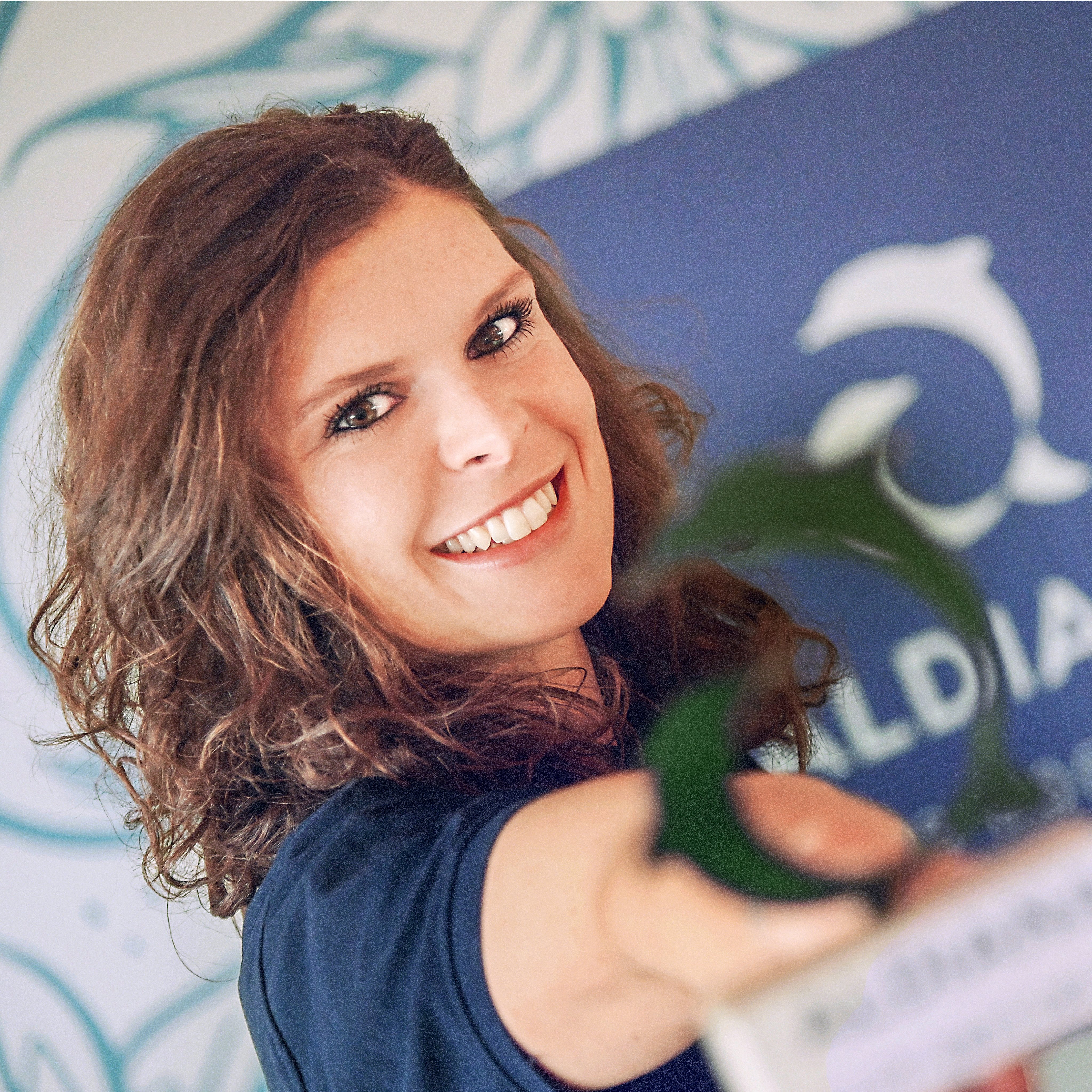 Ein Mensch mit buntem Haar hält einen Preis bei einem Aldiana Cluburlaub.