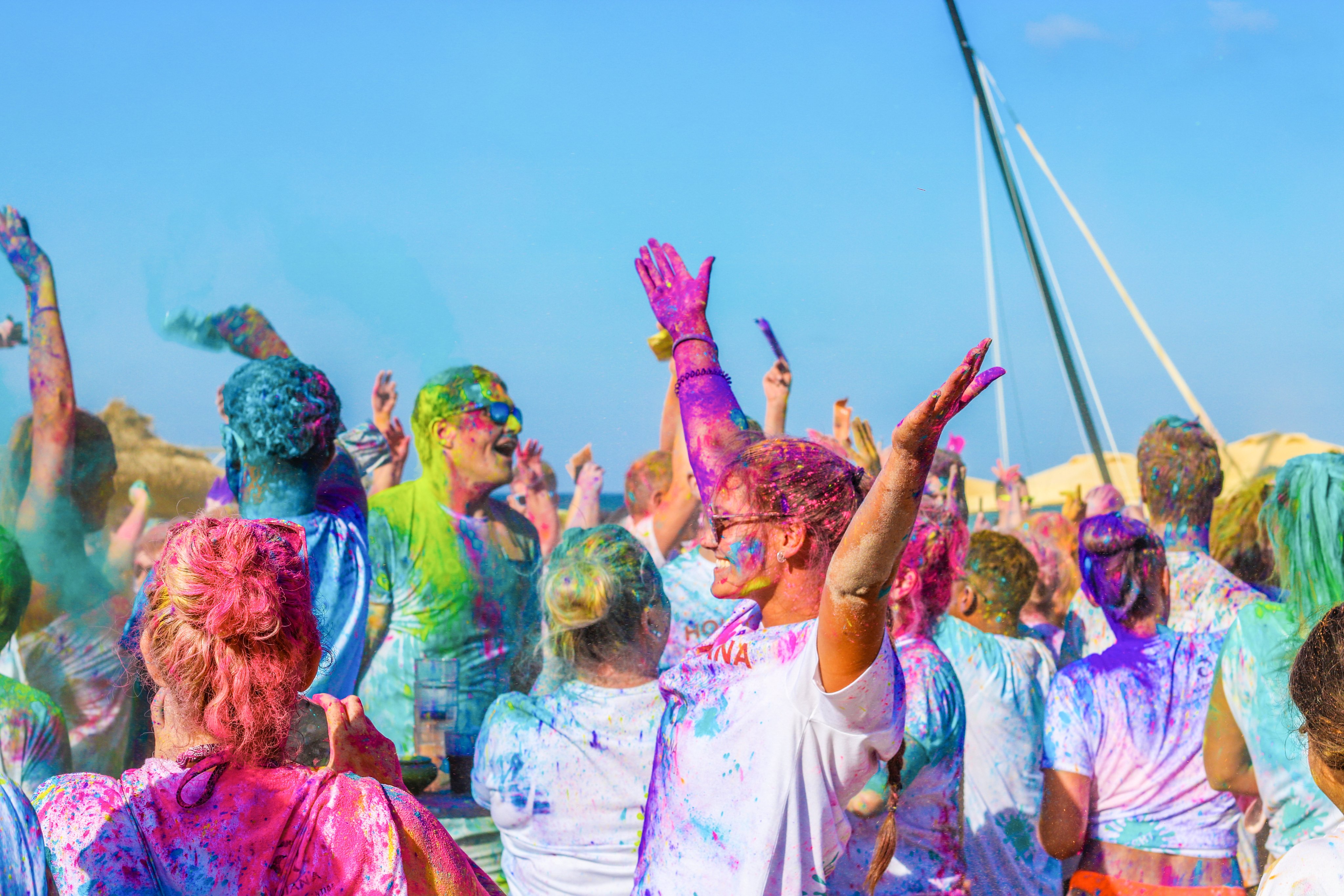 Bunte Holi-Feier bei Aldiana mit tanzenden Menschen im farbenfrohen Festumfeld