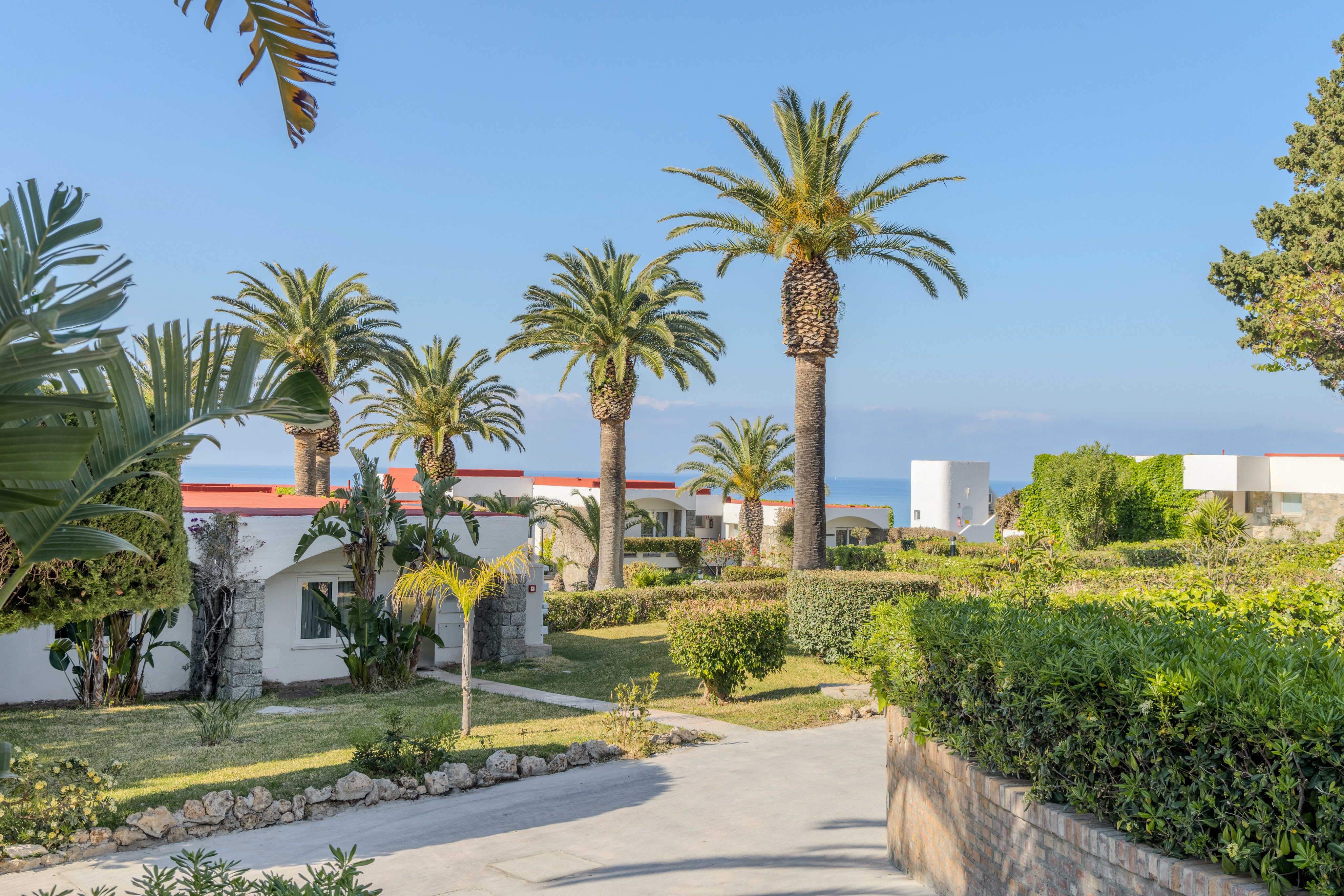 Luxuriöse Hotelanlage mit Palmen, grünen Gärten und Blick auf das Meer bei Aldiana