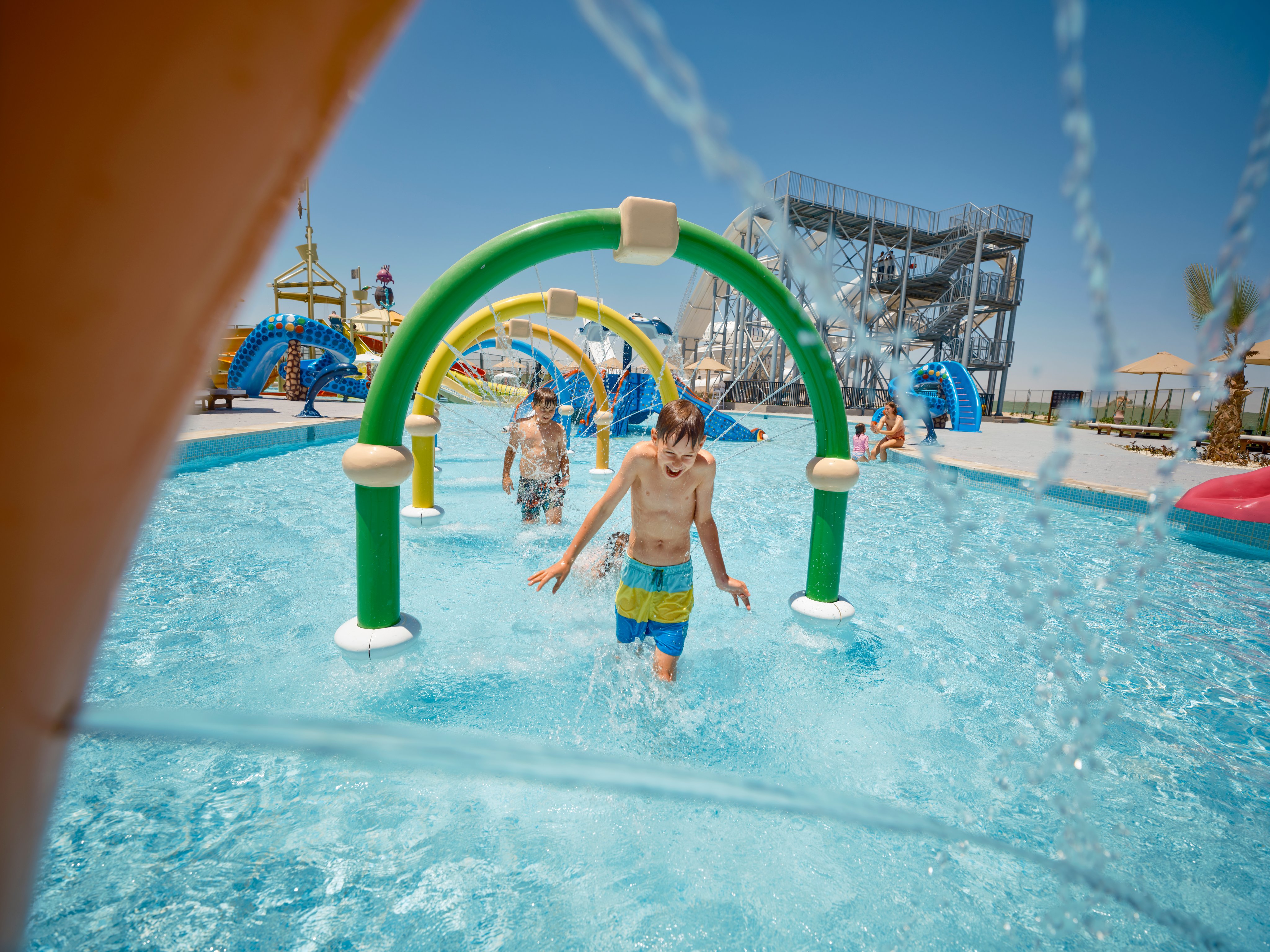 Kinder spielen im Wasserpark eines Aldiana Premium Clubs mit Wasserattraktionen und Rutschen