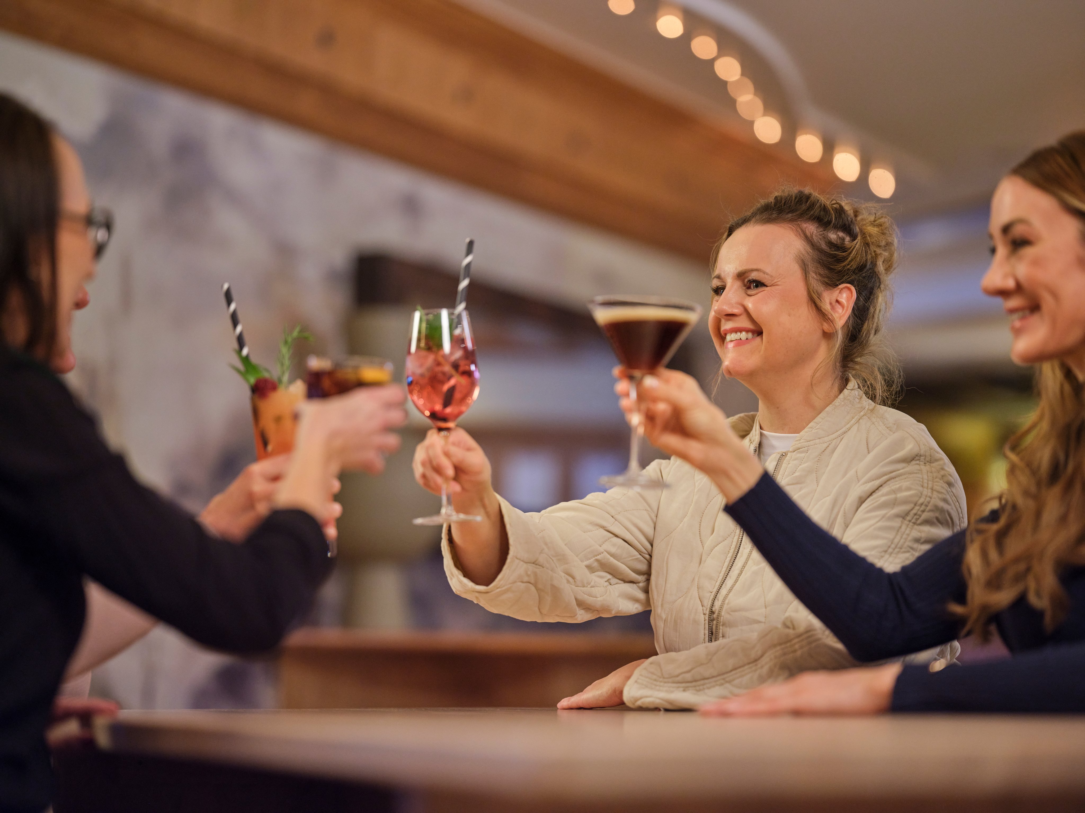 Menschen beim Anstoßen in einer eleganten Bar während eines Premium Cluburlaubs bei Aldiana