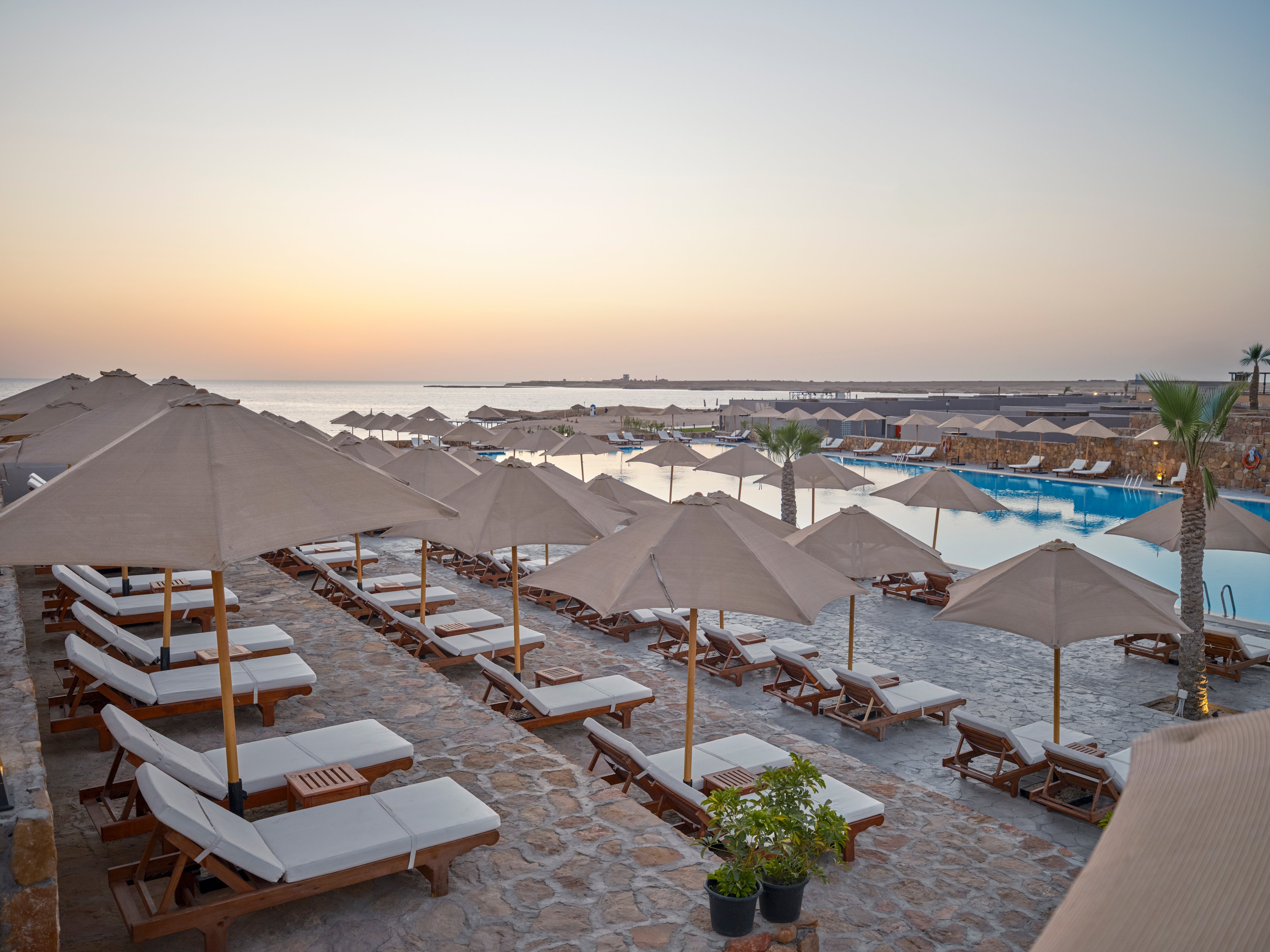 Strandhotel mit Sonnenschirmen, Liegen und Blick aufs Meer bei Aldiana, Urlaubsatmosphäre.