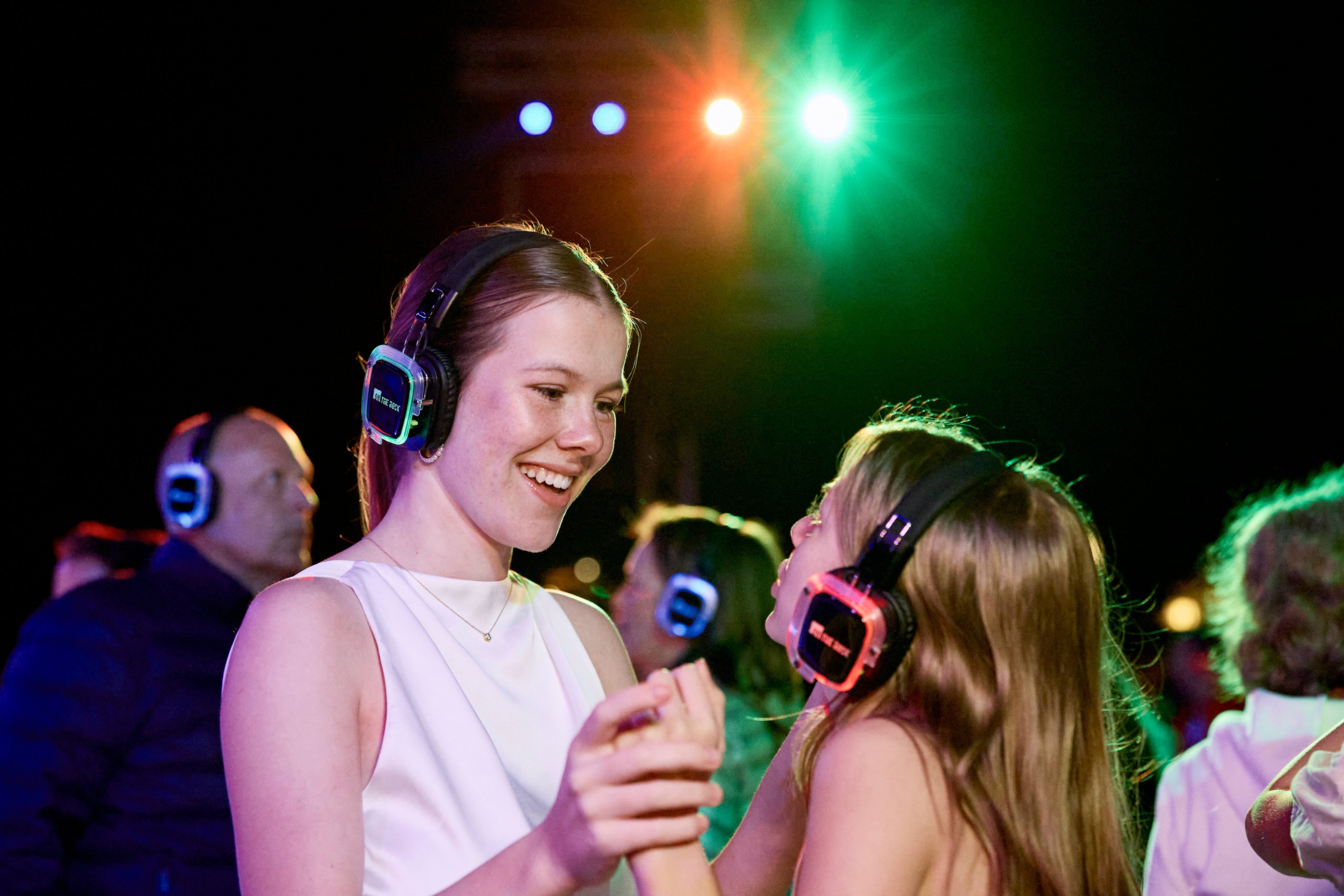 Zwei Jugendliche mit Kopfhörern tanzen bei einem Cluburlaub von Aldiana, lebendige Atmosphäre.